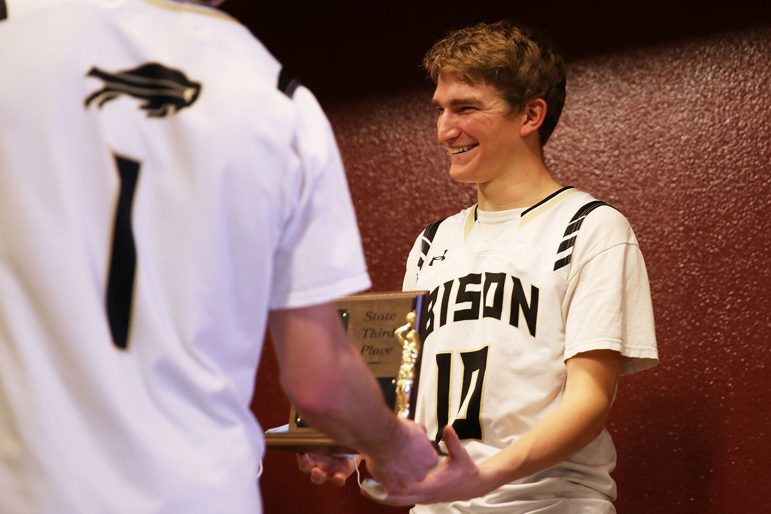 The trophy is handed off to senior Taylor Swanston